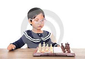 Chinese little girl with glasses frame playing chess seriously