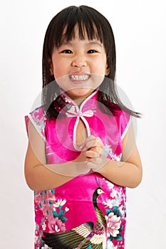 Chinese Little Girl wearing Cheongsam with greeting gesture