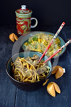 Chinese Lo mein noodles in bowl with fortune cookies