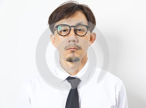 Chinese man wearing white shirt over white background with hand on chin thinking about question.