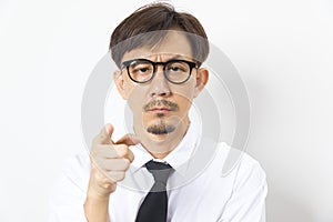 Chinese man wearing white shirt over white background with hand on chin thinking about question.