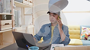 Chinese man working in remote doing simultaneous tasks