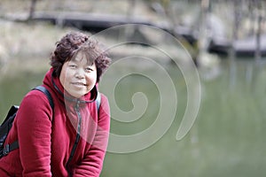 Chinese middle-aged woman by lake of jiuxianshan mountain, adobe rgb