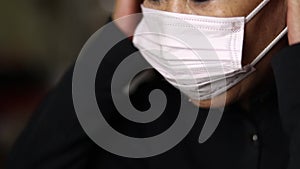 Chinese middle aged woman putting on mask for protection from corona virus during pandemic in Beijing, China