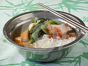 Chinese Mifen noodles soup with roast pork and lettuce