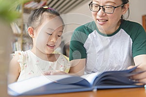 Chinese mom and daughter reading together