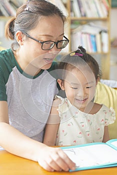 Chinese mom and daughter reading together