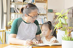Chinese mom and daughter reading together