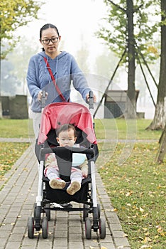 Mom push daughter in baby carseat photo