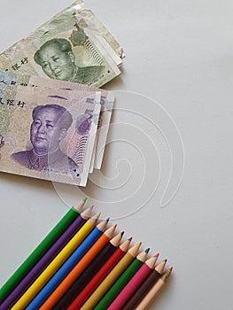 Chinese money and color pencils on the white background