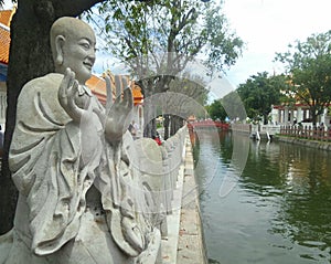 Chinese monk stone sculpture at Benjamabopit temple photo