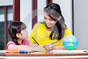 Chinese mother doing school homework with child