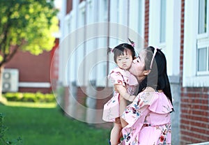 Chinese mother kiss her little daughter