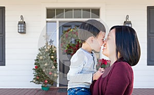 Chinese Mother and Mixed Race Child Rubbing Noses Standing on Christmas Decorated Front Porch