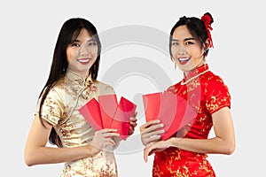 Chinese new year concept. Two Asian women in Cheongsam dres holding red envelopes or Ang Pow