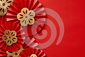 Chinese New Year festival or wedding decorations on red background. Red paper fans with gold decorations top view. Lunar New Year