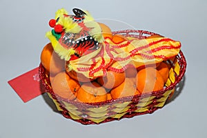 Chinese New Year, orange fruit basket with Chinese Dragon and angpao facing left close up
