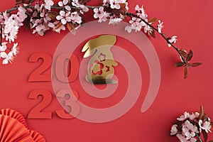 Chinese New Year, year of the rabbit. Year 2023 with golden rabbit and plum blossom fans. Copy space.