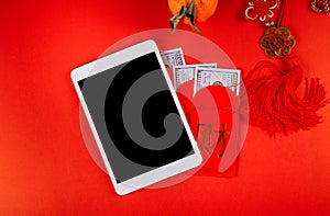 Chinese new year symbol decorations ornament Ang Pau money packet on red background and digital tablet