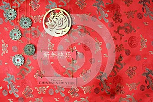 Chinese New Year of the Tiger 2022. Golden tiger symbol, five lucky coins with chinese zodiac on red fabric with traditional