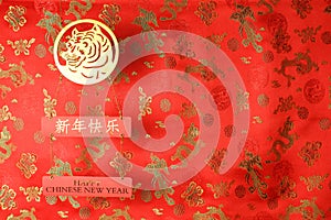 Chinese New Year of the Tiger 2022. Golden tiger symbol on red fabric with traditional chinese ornament birds and dragons.