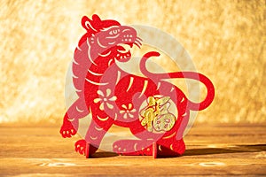 A Chinese New Year of tiger 2022 mascot paper cut on a wood table in the morning the Chinese means fortune no logo no trademark