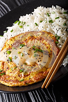 Chinese omelette Egg Foo Young served with rice close-up. vertical