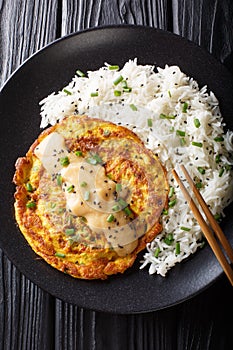 Chinese omelette Egg Foo Young served with rice close-up. Vertical top view
