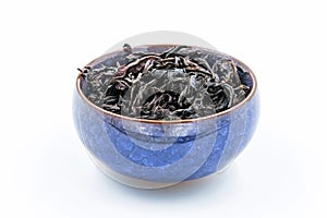 Chinese Oolong Dark Red tea WuYi Rou gui in a blue ceramic bowl