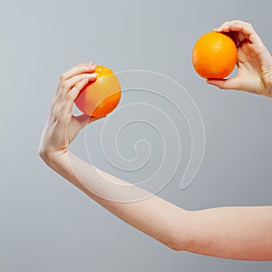 Chinese Orange on Asian woman hand on gray concrete background