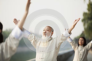 Chinese People Practicing Tai Ji, Arms Raised, Outdoors