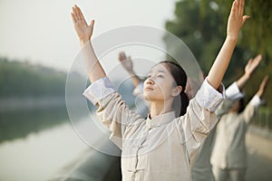 Chinese People Practicing Tai Ji, Arms Raised, Outdoors