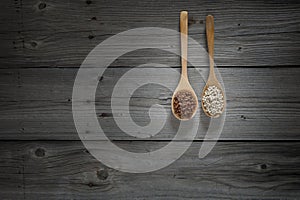 Chinese pepper and white peper on wooden spoons and wooden background