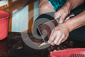 Chinese person peeling skin off small fish