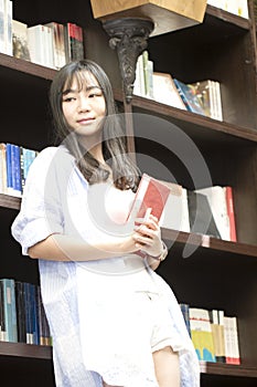 Chinese Portrait of young beautiful woman hold education books In Bookstore