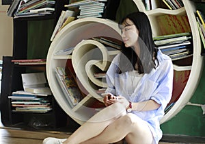 Chinese Portrait of young beautiful woman Listen to the music In Bookstore