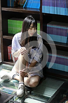 Chinese Portrait of young beautiful woman Listen to the music In Bookstore