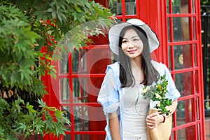 Chinese Portrait of young beautiful woman near the old phone booth