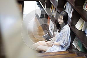 Chinese Portrait of young beautiful woman reads Book In Bookstore