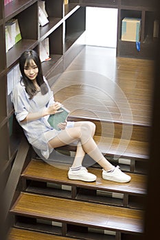 Chinese Portrait of young beautiful woman reads Book In Bookstore