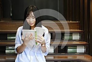 Chinese Portrait of young beautiful woman reads Book In Bookstore