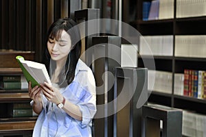 Chinese Portrait of young beautiful woman reads Book In Bookstore