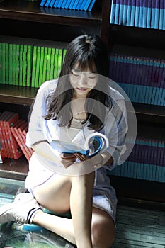 Chinese Portrait of young beautiful woman reads Book In Bookstore