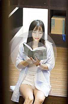 Chinese Portrait of young beautiful woman reads Book In Bookstore