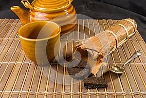 Chinese pressed PU-erh tea in bamboo leaf packaging and tea accessories, close-up, macro