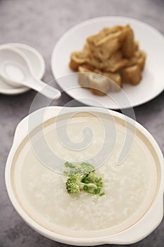 Chinese rice congee with pieces of fried bread sticks. Conceptual image