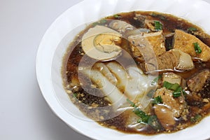 Chinese roll noodle soup with crunchy pork, egg and cinnamon