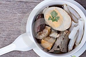 Chinese roll noodle soup on wood background, top view