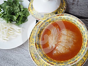 Chinese Shark`s Fin Soup with brown sauce serve in Royal yellow bowl.
