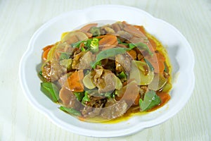 Chinese stir-fried fresh meat with carrots, green peppers, potatoes on white plate, top view photo